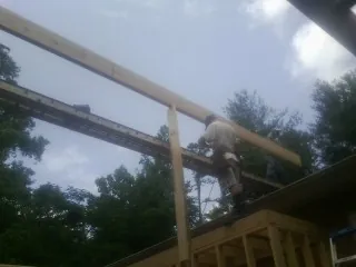 Carpenter setting a ridge beam over a new addition frame — Ice Dam Removal by Roofing Brothers in Santa Barbara